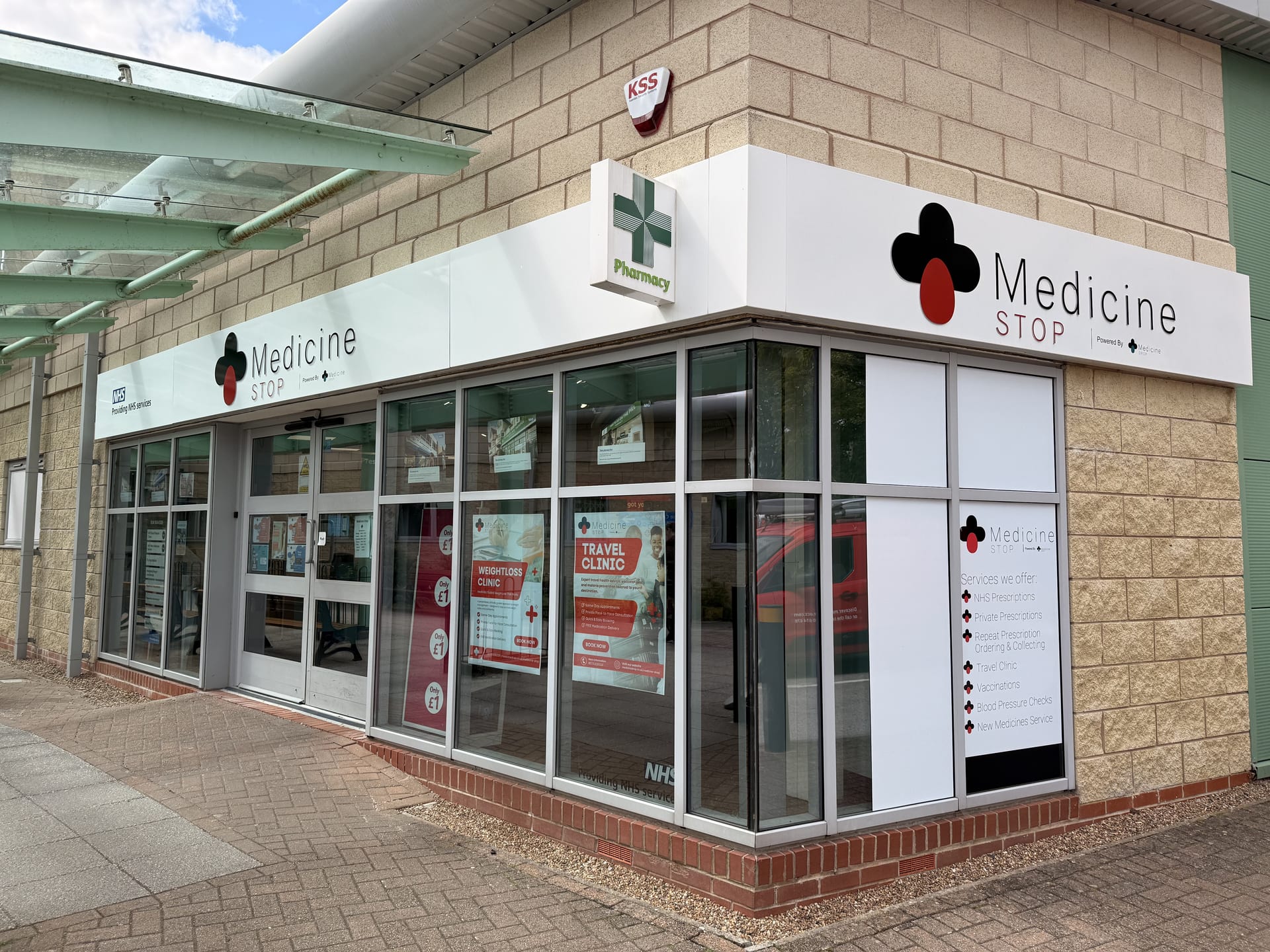 Medicine Stop shopfront with a travel-clinic promotional display.